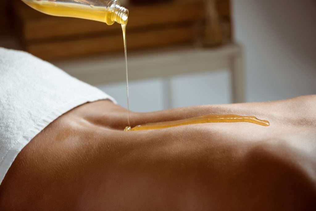 huile de massage qui tombe sur le creux du dos